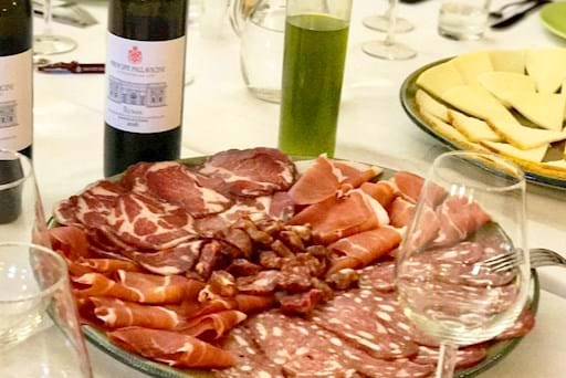 Delicious cured meat plate with cheese and wine
